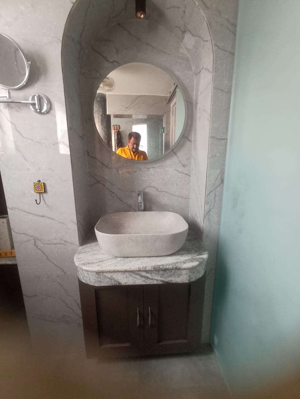 Modern bathroom renovation with marble vanity and arched backlit mirror